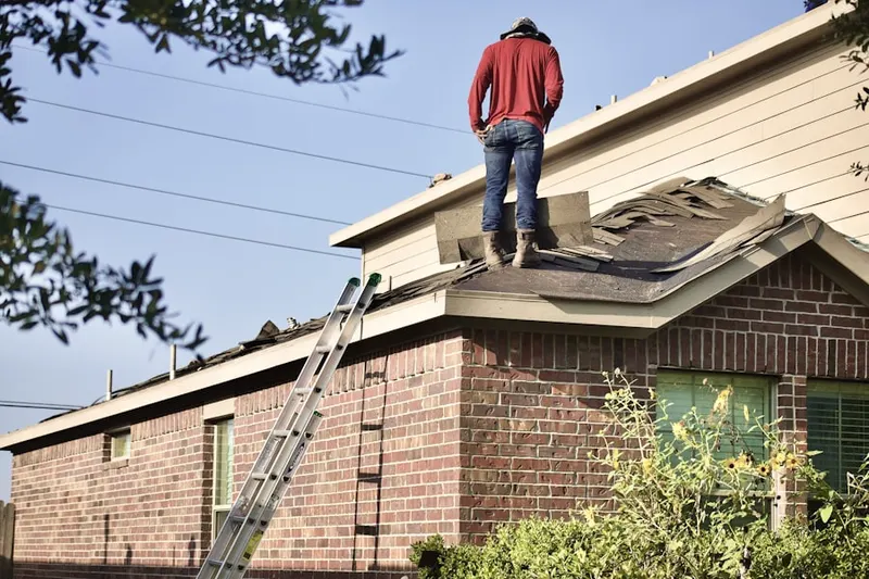 Professional roofer working on a residential roof in Washington Heights